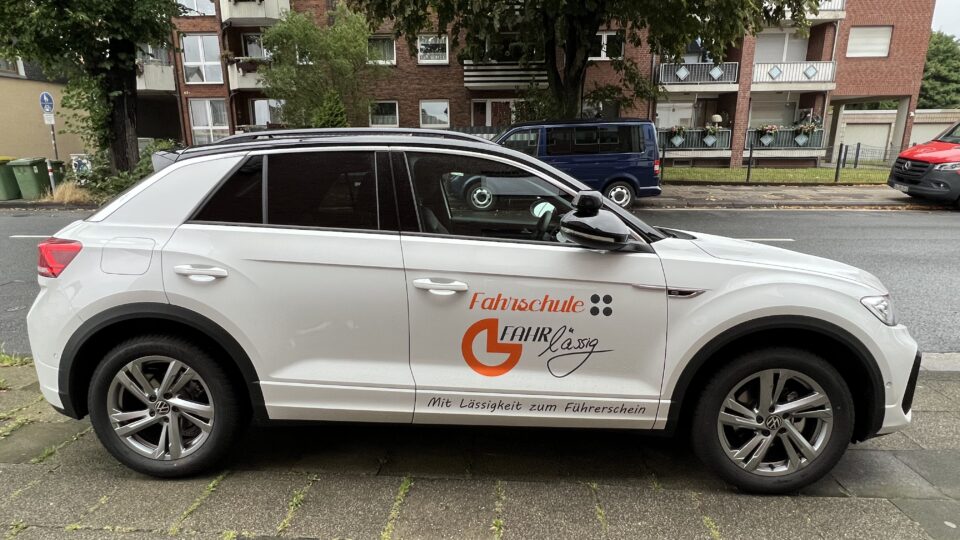Fahrschulauto der Fahrschule FAHRlässig, weißer VW SUV mit Logo und Slogan Mit Lässigkeit zum Führerschein